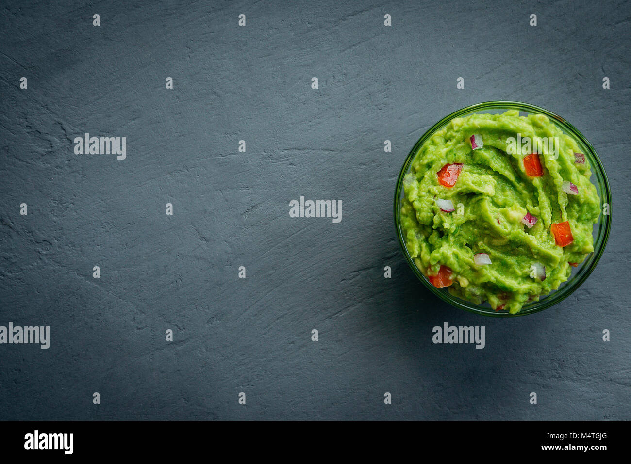 Guacamole bowl on a stone table. Top view image. Copyspace for your text. Stock Photo