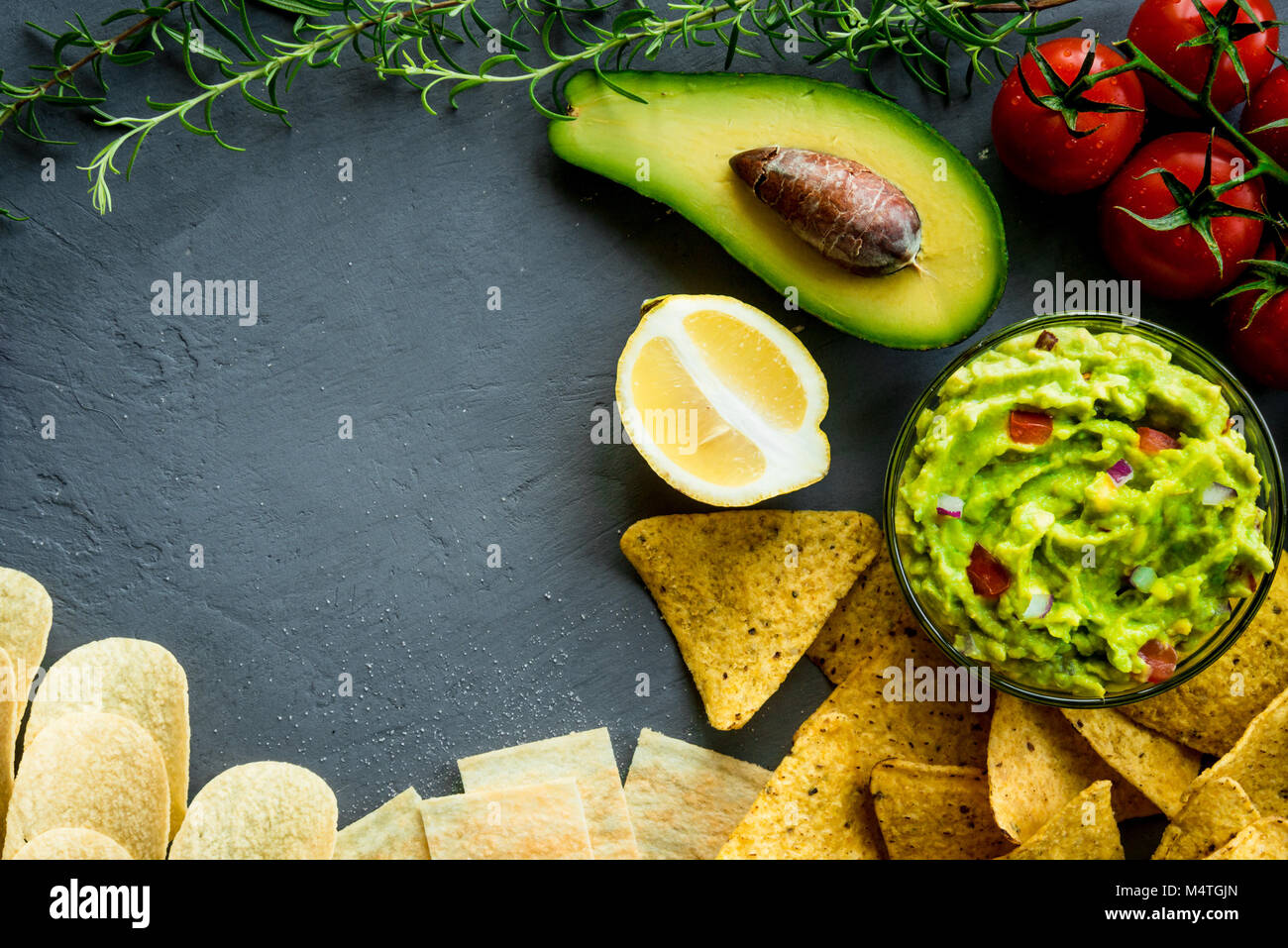 Guacamole bowl with ingredients and tortilla different tipes of chips