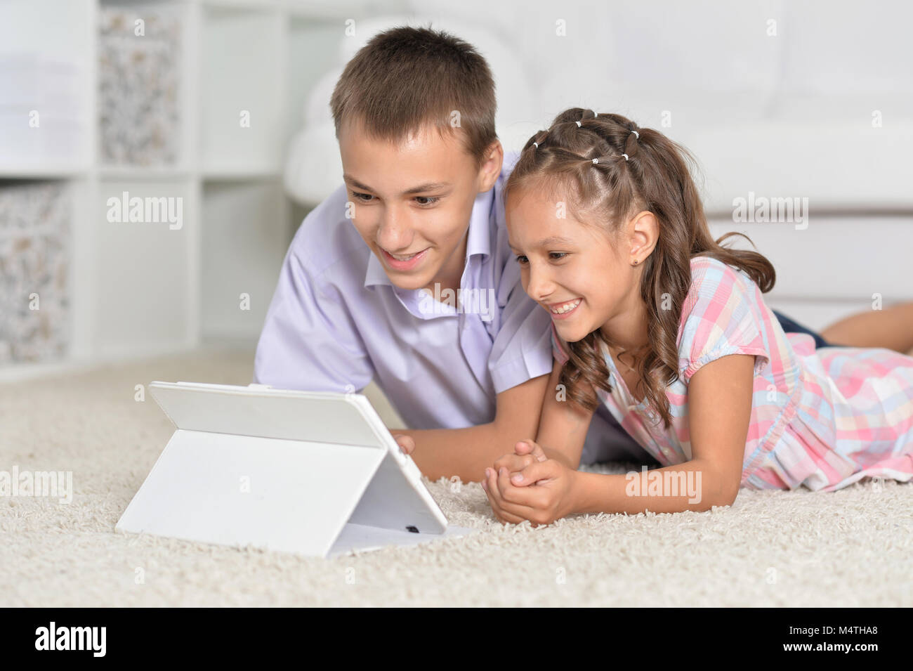 Brother and sister using tablet Stock Photo - Alamy