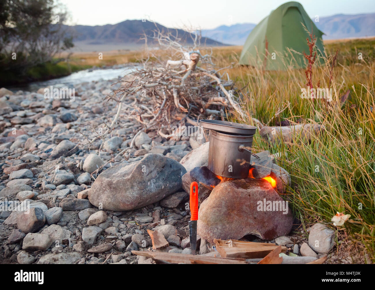 Cooking meal in a kettle on burning campfire in wild camping Stock ...