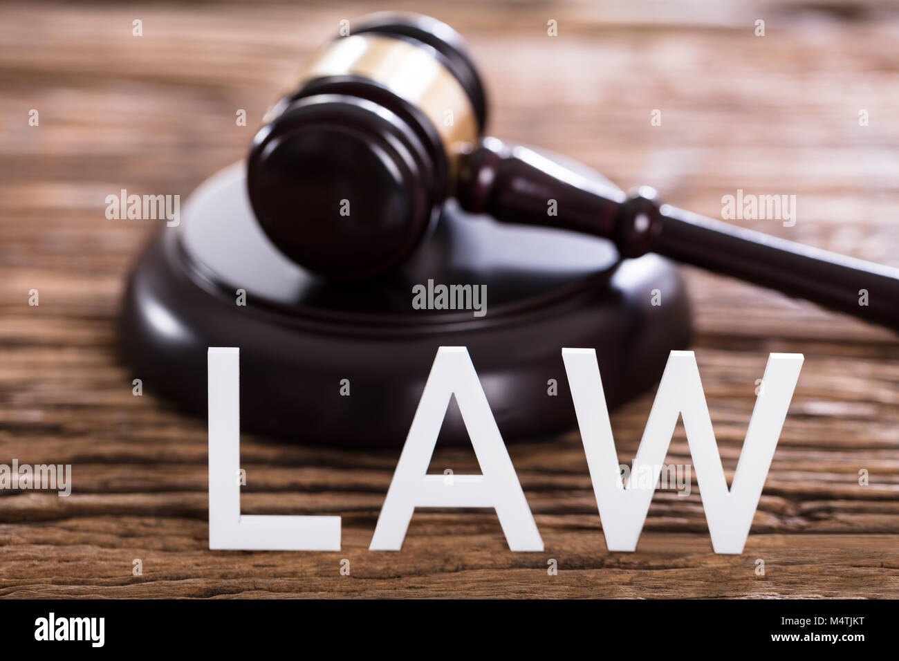 Close-up Of A Law Text In Front Of Gavel On Wooden Desk Stock Photo