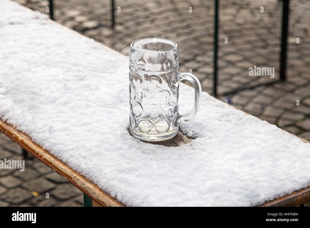 Forgotten beer mug in the snow on Viktualienmarkt in Munich Stock Photo