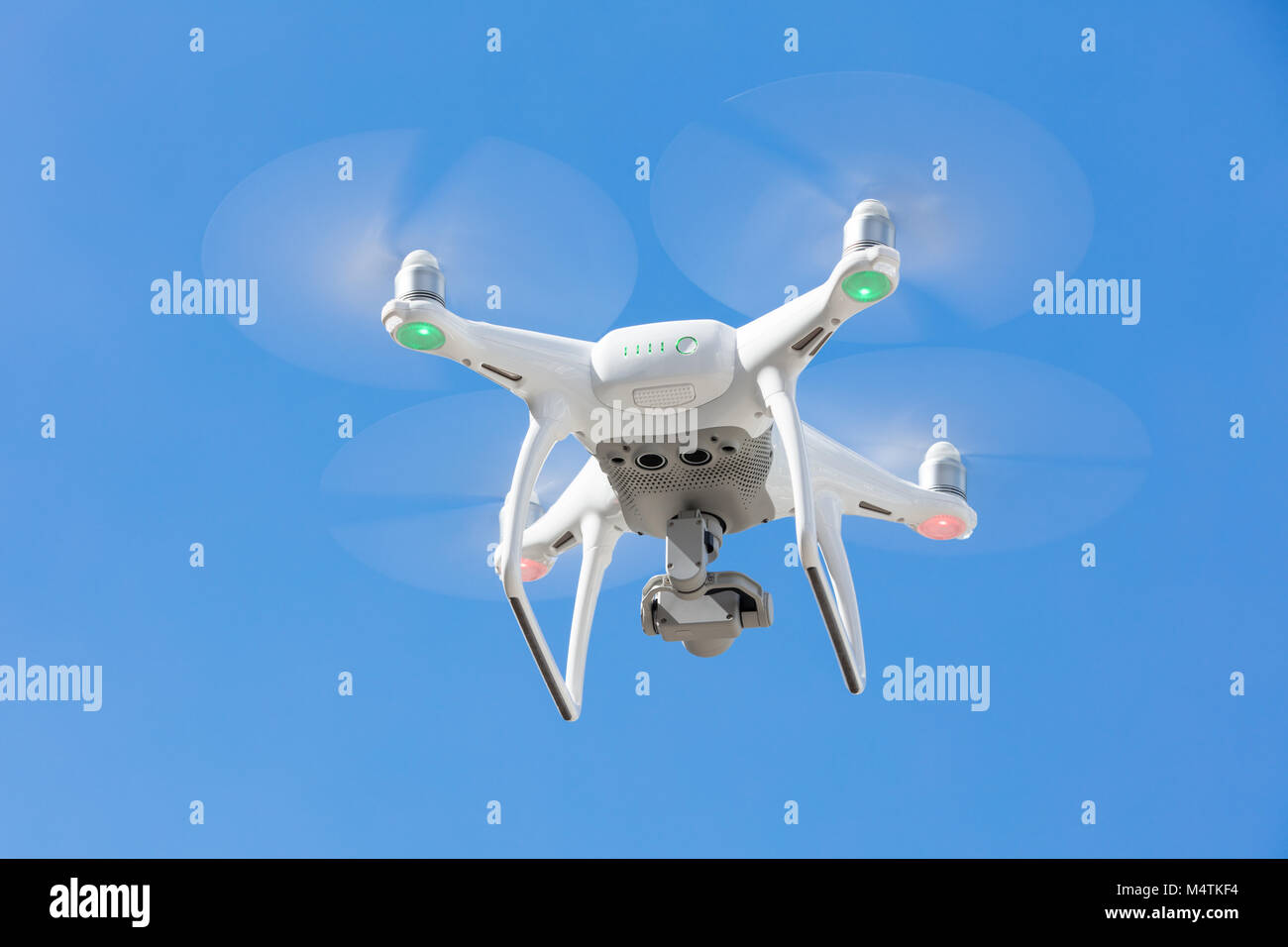 Low angle view of drone flying against clear blue sky Stock Photo