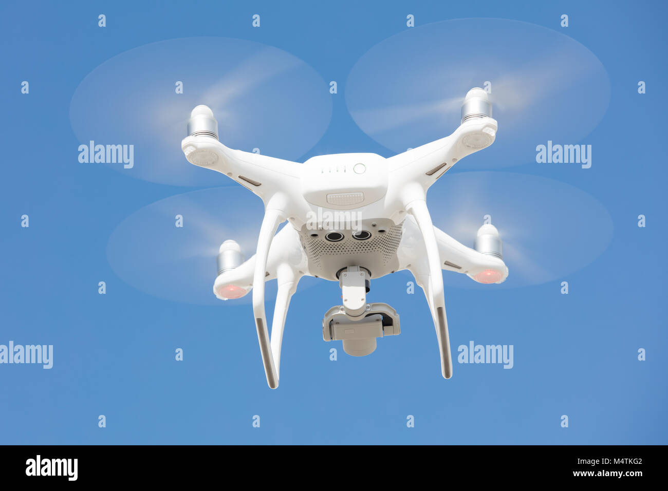 Low angle view of drone flying against blue sky Stock Photo
