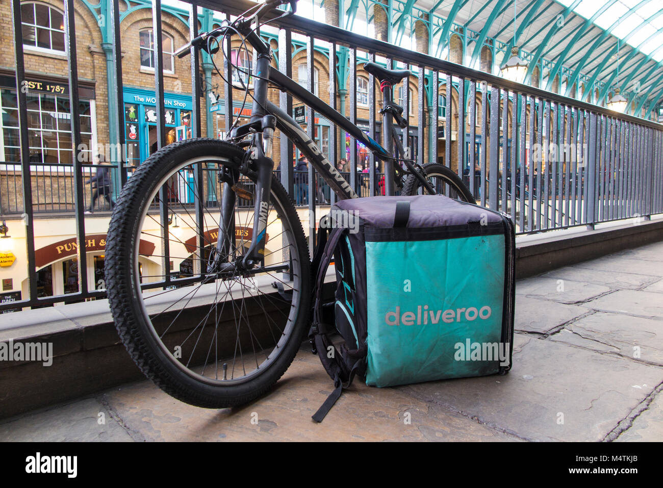 A parked Deliveroo rider's bike and Deliveroo bag in Covent Garden, London Stock Photo