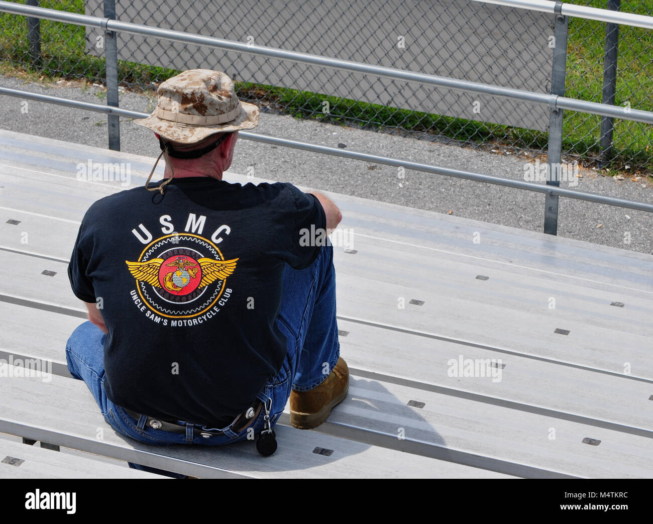 US Marine Veteran at Budds Creek International Raceway watching motor cycle racing USMC tee shirt and camouflage hat on Stock Photo
