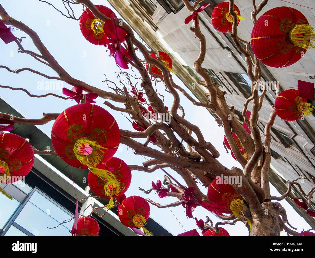 Chinese Lanterns on display in large bonsai style wishing tree in Regent Street with red envelopes for good luck Stock Photo