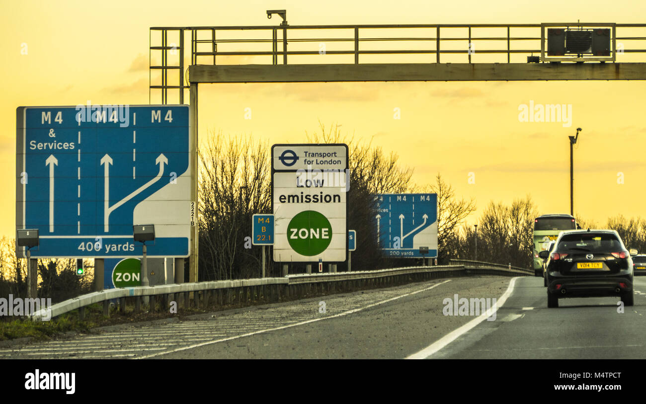 Low Emission Zone signpost next to the hard shoulder by Transport for London TFL, plus lane signs on the M4 motorway west of London, England, UK. Stock Photo