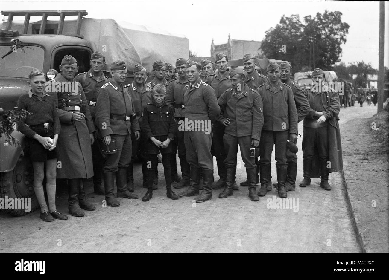 German Army soldiers with young boys from the Hitler Youth as they prepare to leave for France in the early part of the second World War Stock Photo