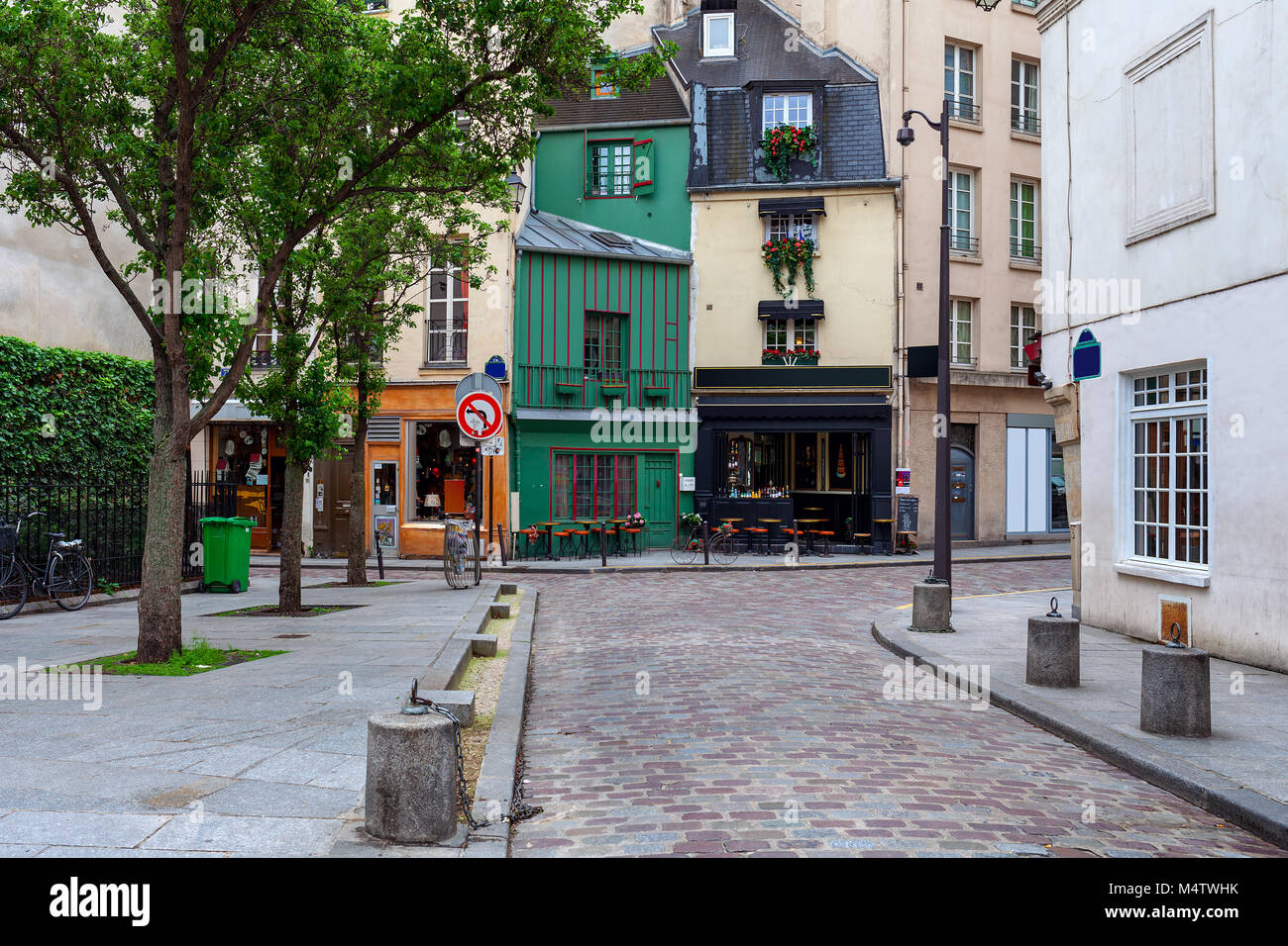 View of small cobblestone street with little bar, shops and typical architecture in Paris, France. Stock Photo