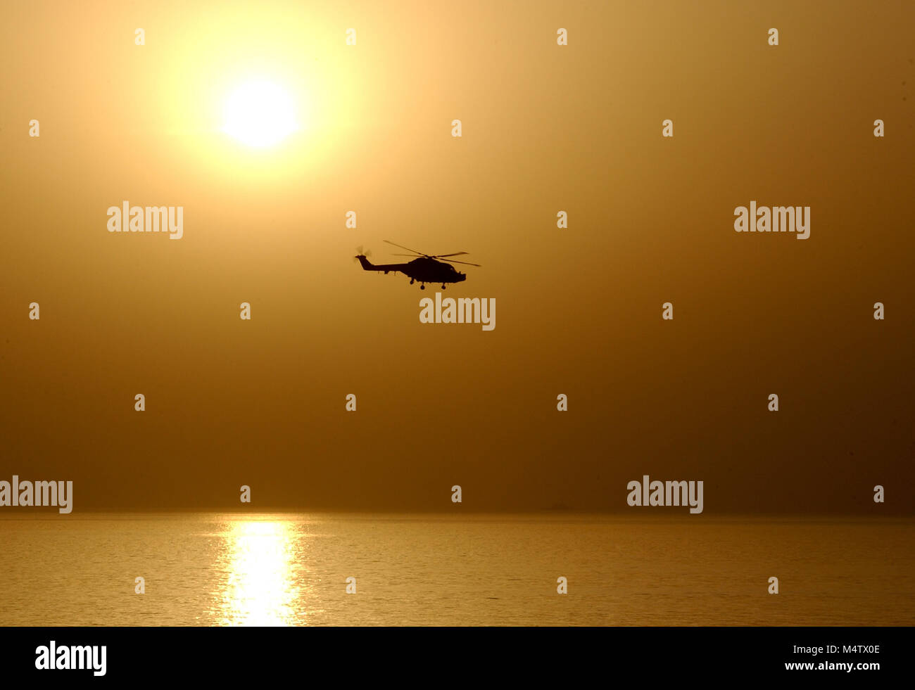 Sunset and a Royal Navy Lynx helicopter Stock Photo