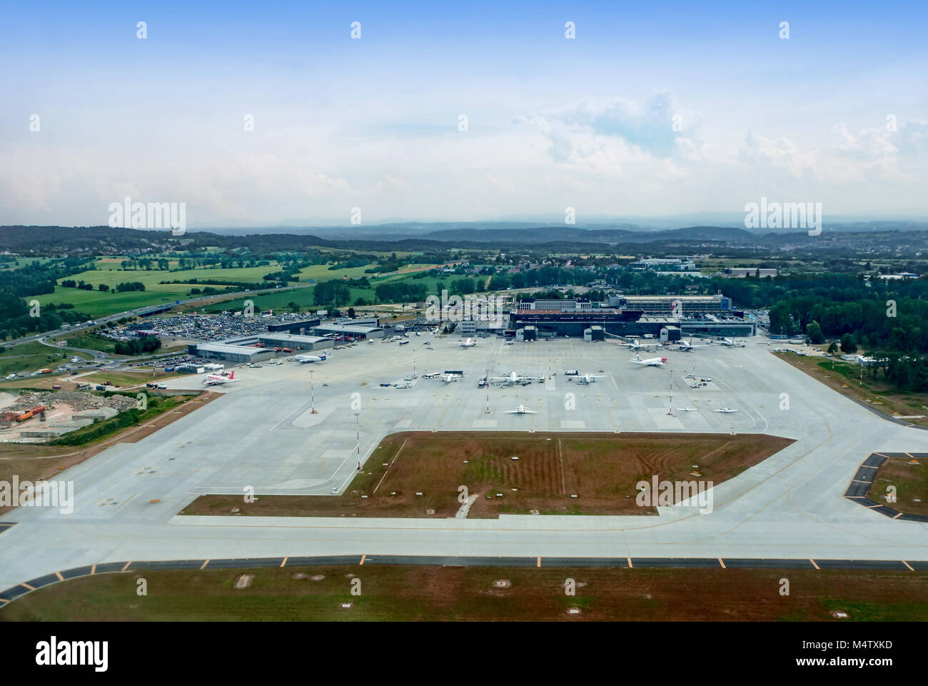 Krakow, Poland –June 27, 2017: International airport in Balice with apron, terminals, aircrafts, taxiways, construction site, parking and highway. Aer Stock Photo