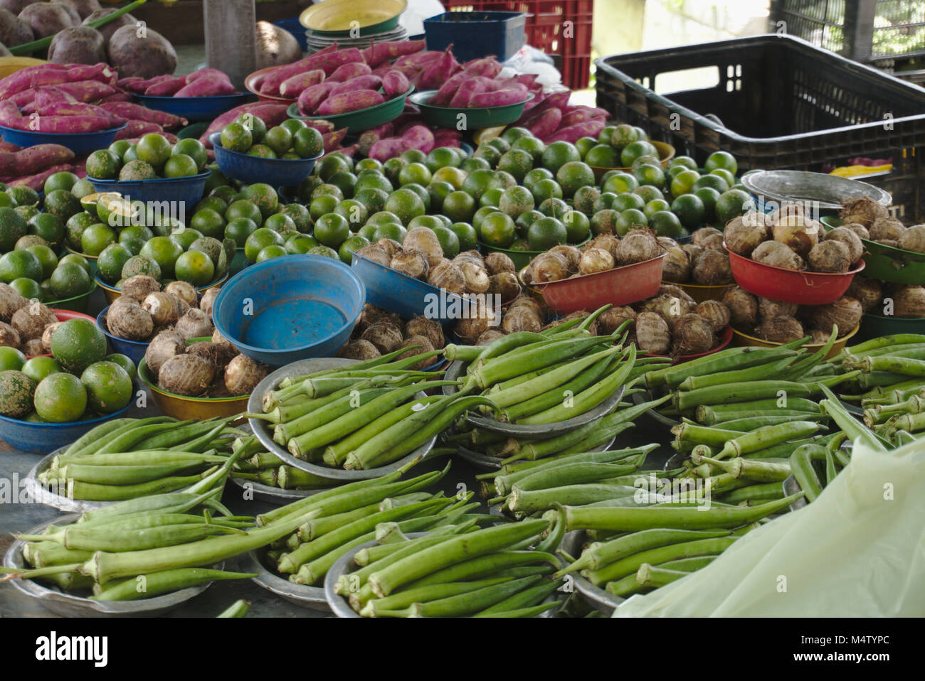 Okra, yam, lime, and red sweet potato at farmers market stall. Stock Photo