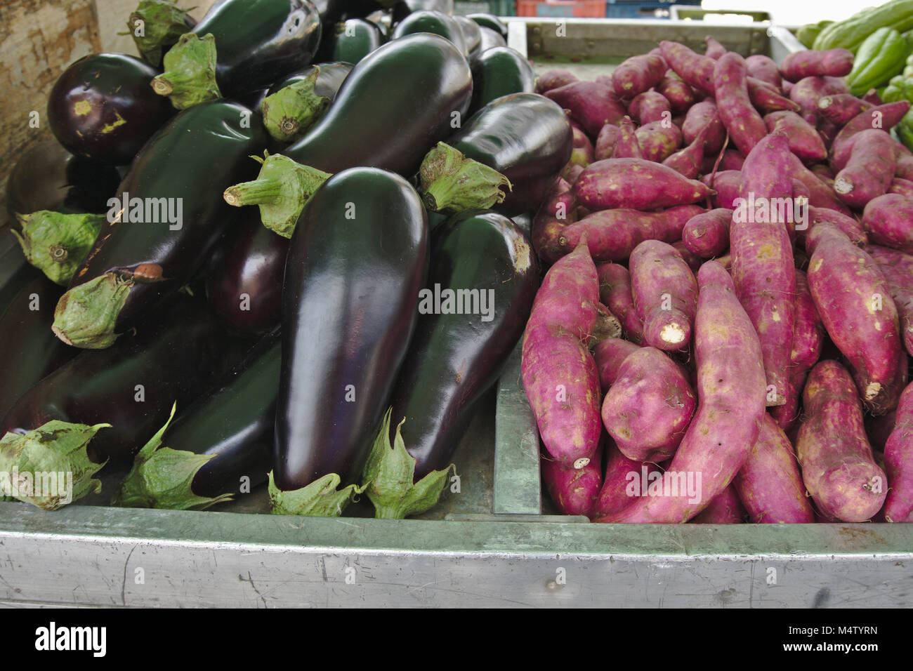 Red sweet potato and eggplant at a farmers market stall. Stock Photo