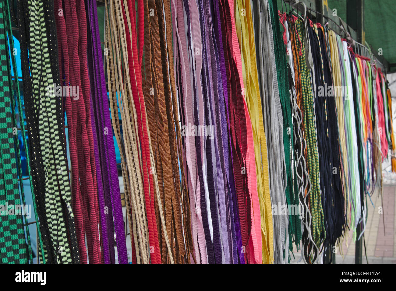 A colorful group of shoelaces hanging in a market stall. Stock Photo
