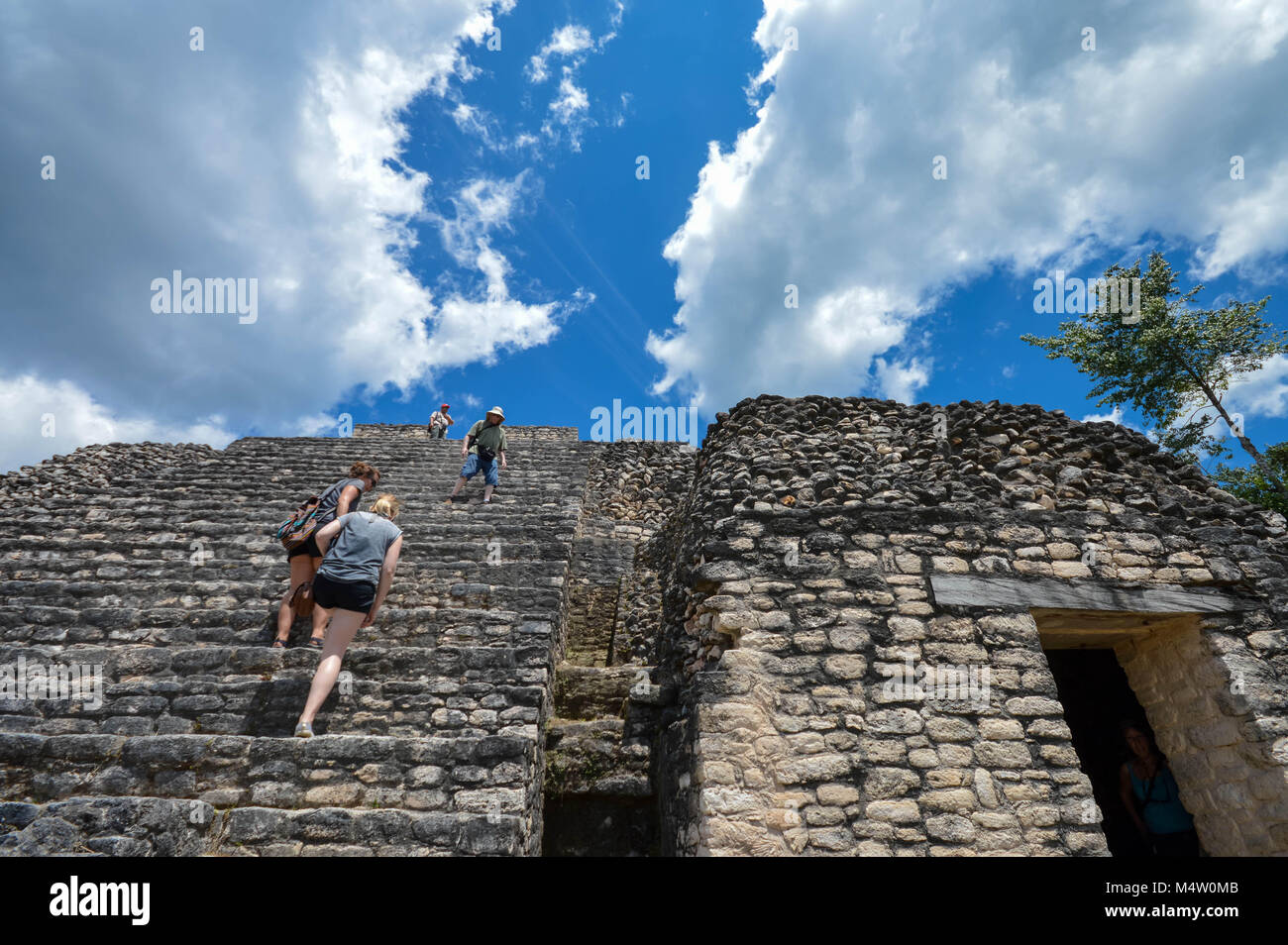 Caracol, Cayo District, Belize - March 22, 2015: Tourists climb the stairs of Caana pyramid at Caracol archaeological site of Maya civilization, Weste Stock Photo
