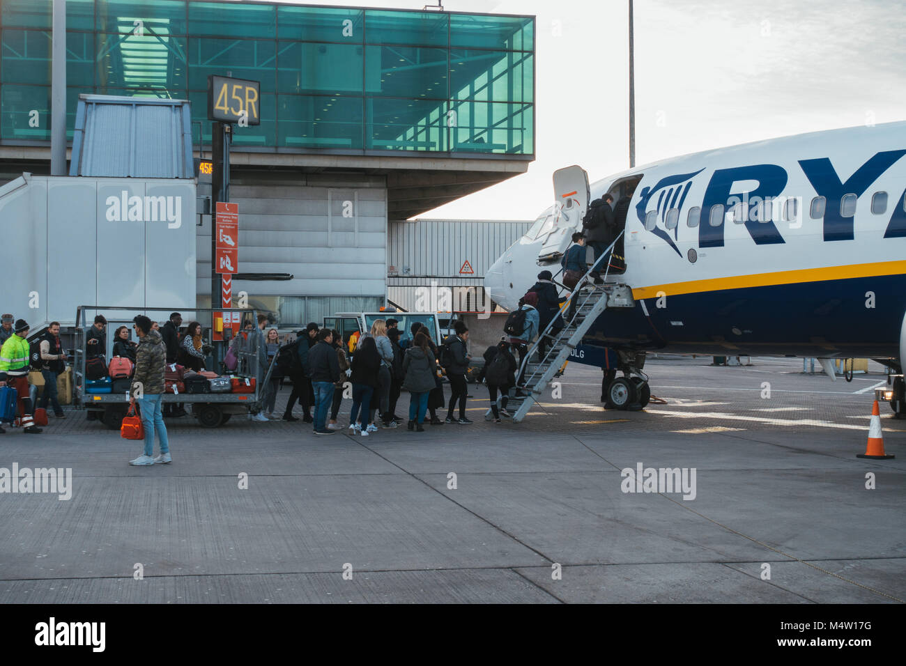 Passengers boarding a Ryanair jet after their new cabin bag policy came into effect - requiring them to forfeit their baggage to loading crews Stock Photo