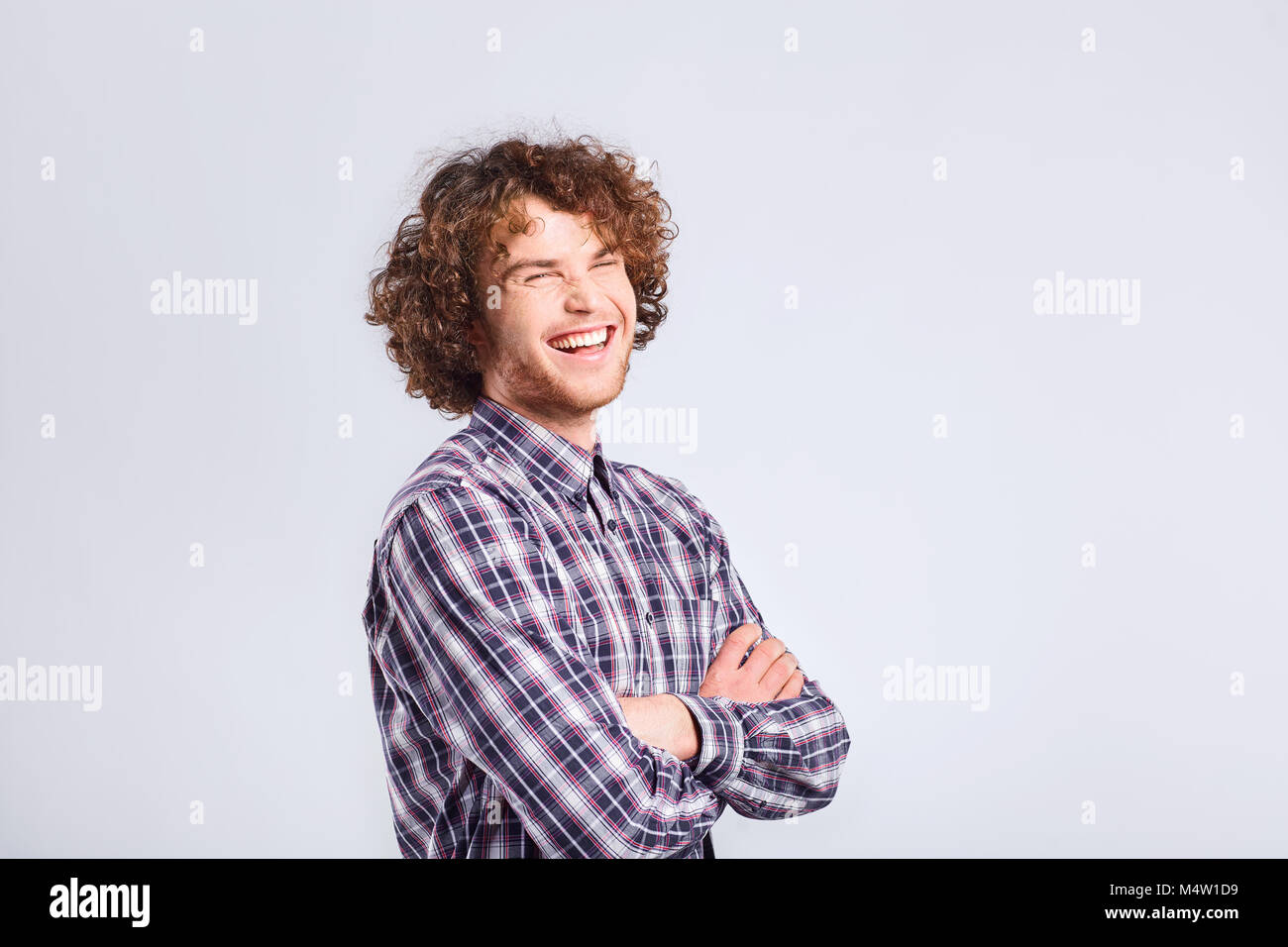 Curly guy smiles with a positive emotion. Stock Photo
