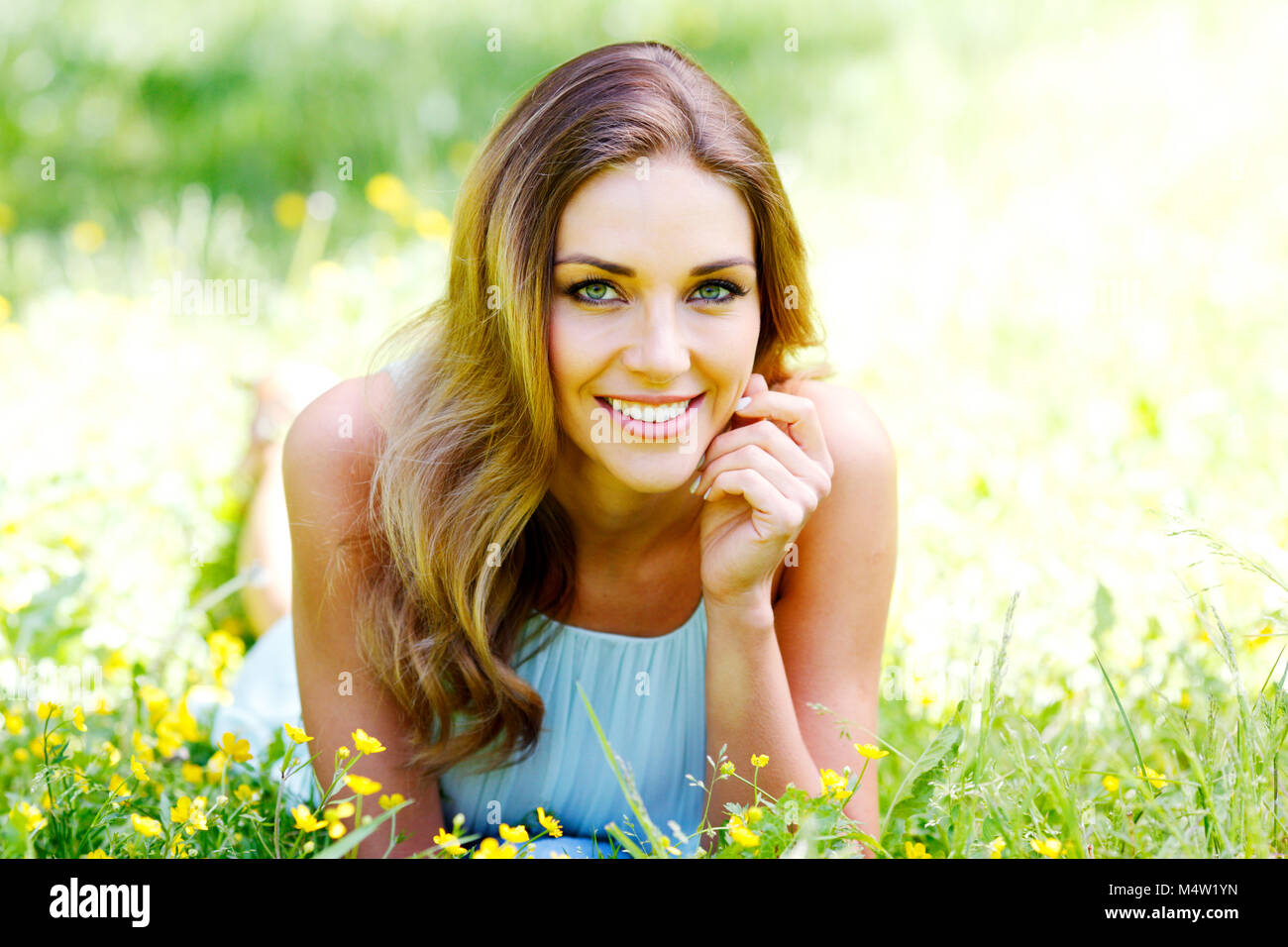 beautiful young woman in blue dress lying on grass Stock Photo - Alamy
