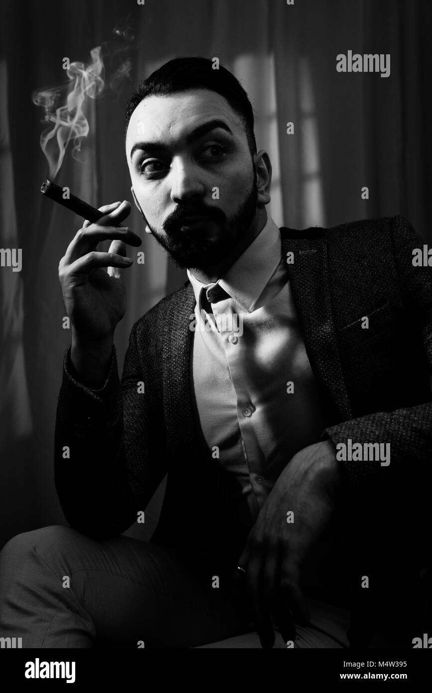 Film Noir concept of man smoking a cigar Stock Photo