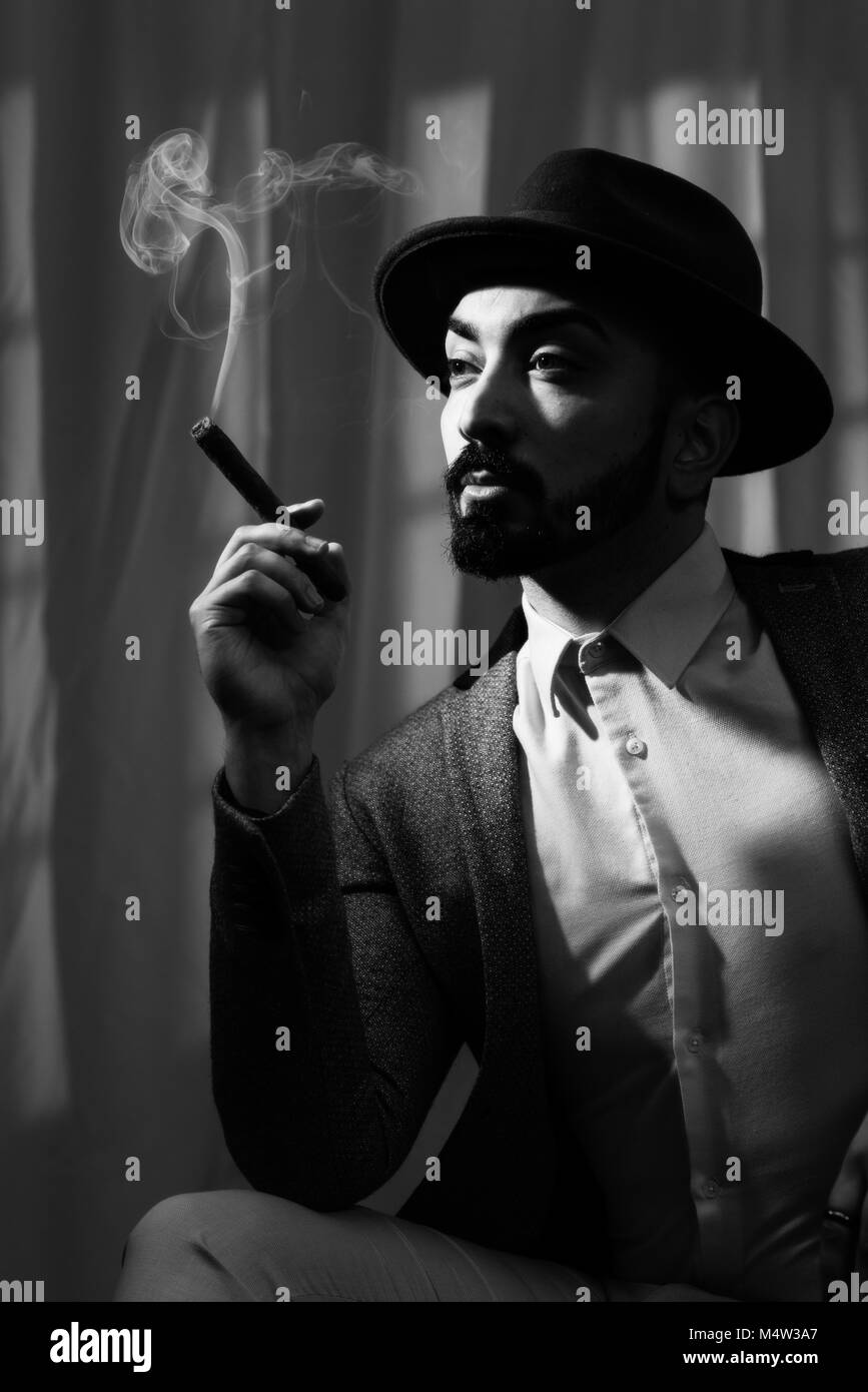 Film Noir concept of man smoking a cigar Stock Photo