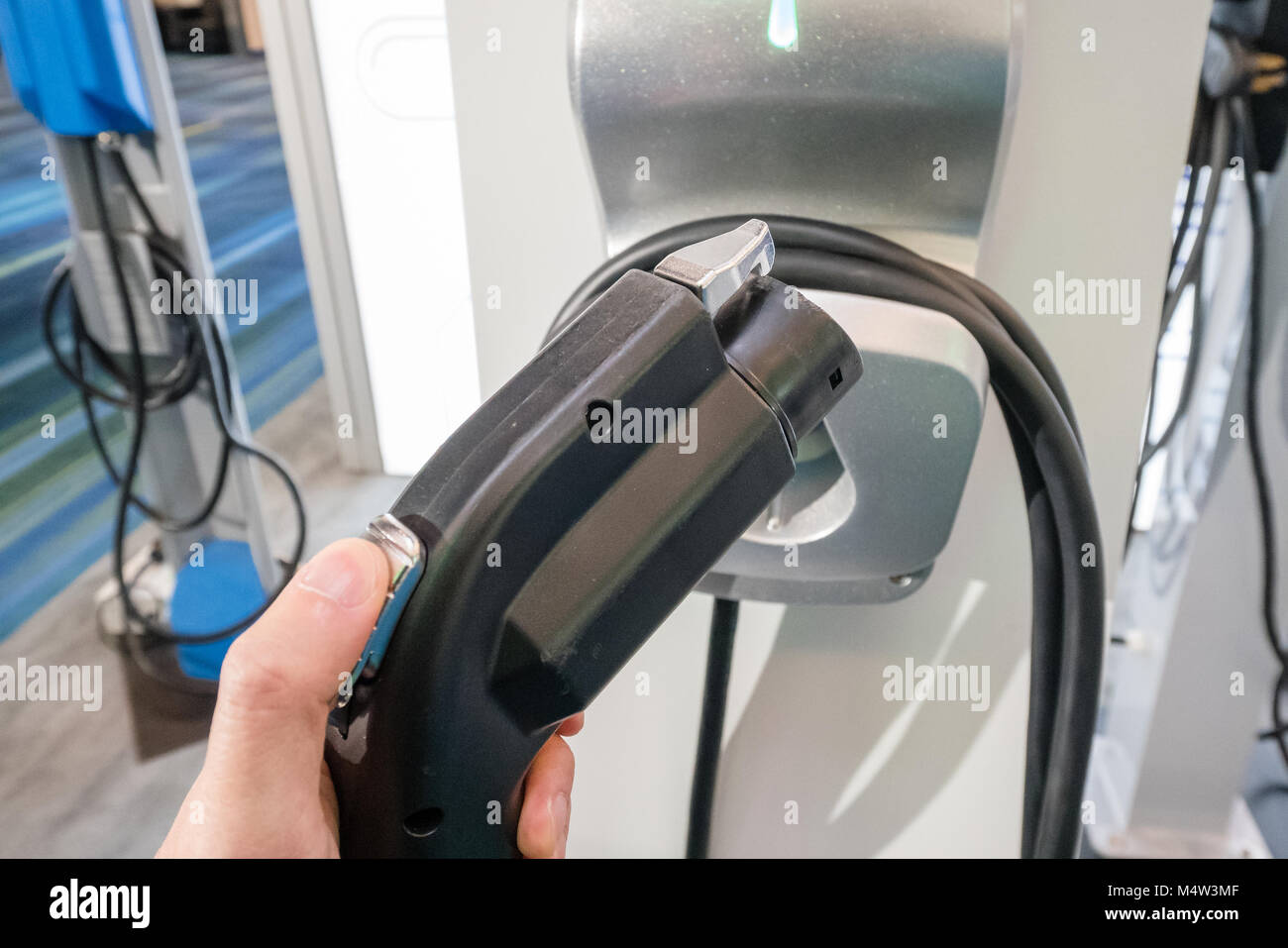 holding electric car charger Stock Photo