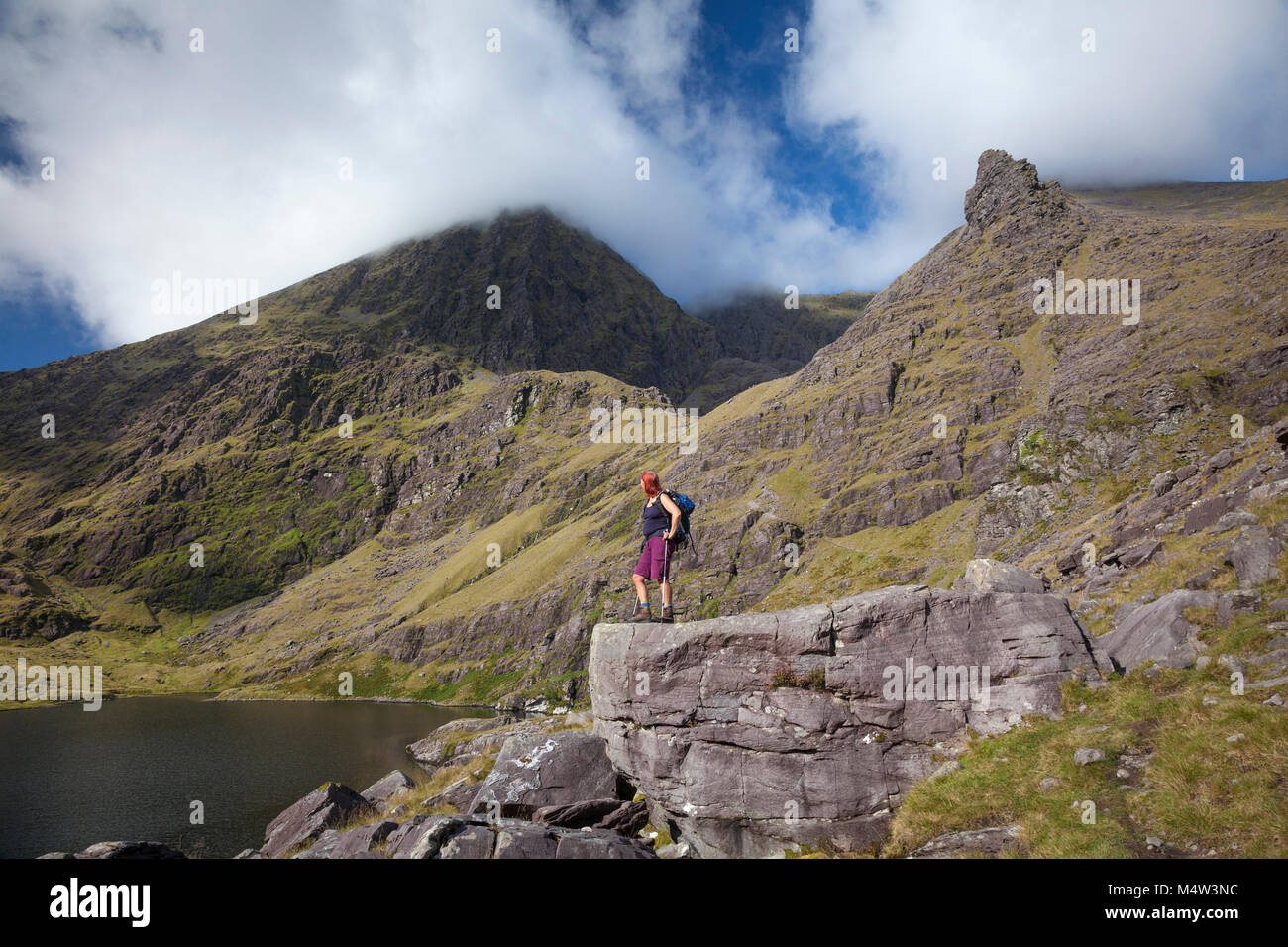 Hiker and Lough Gouragh beneath Carrauntoohil, MacGillycuddy's Reeks, County Kerry, Ireland. Stock Photo