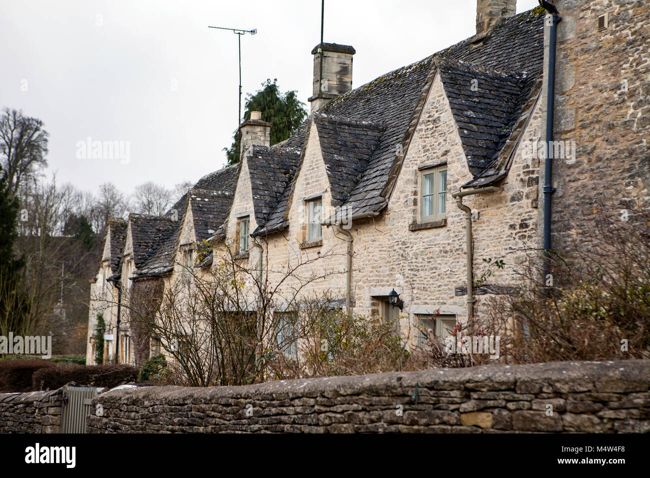 BIBURY, UK - FEBRUARY 15th, 2018: Old houses in Bibury: Bibury is a typical Costwold village with traditional english architecture. Stock Photo
