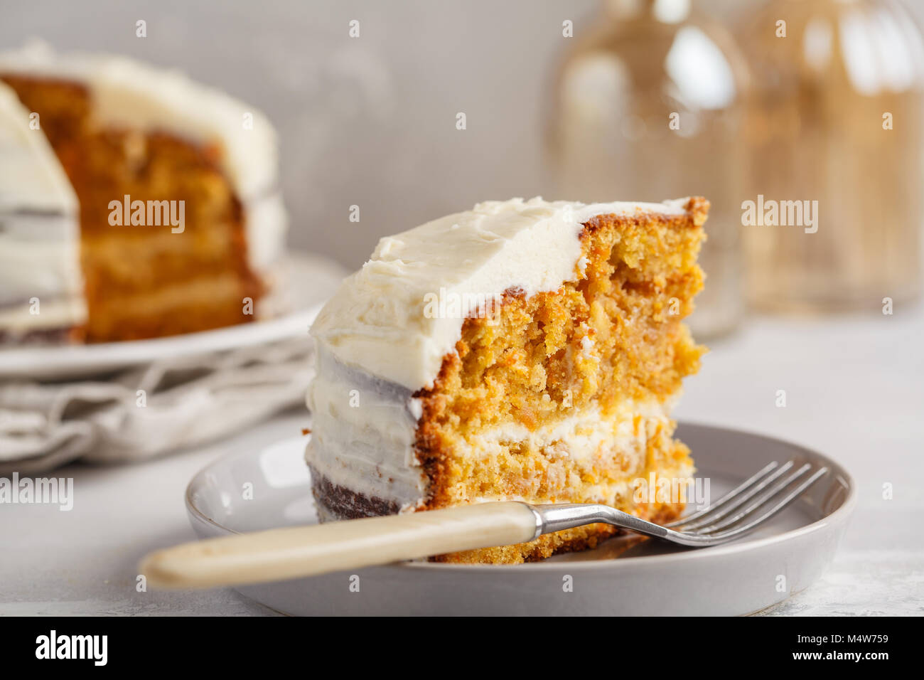 Carrot homemade cake with white cream on a gray background. Festive dessert concept. Stock Photo