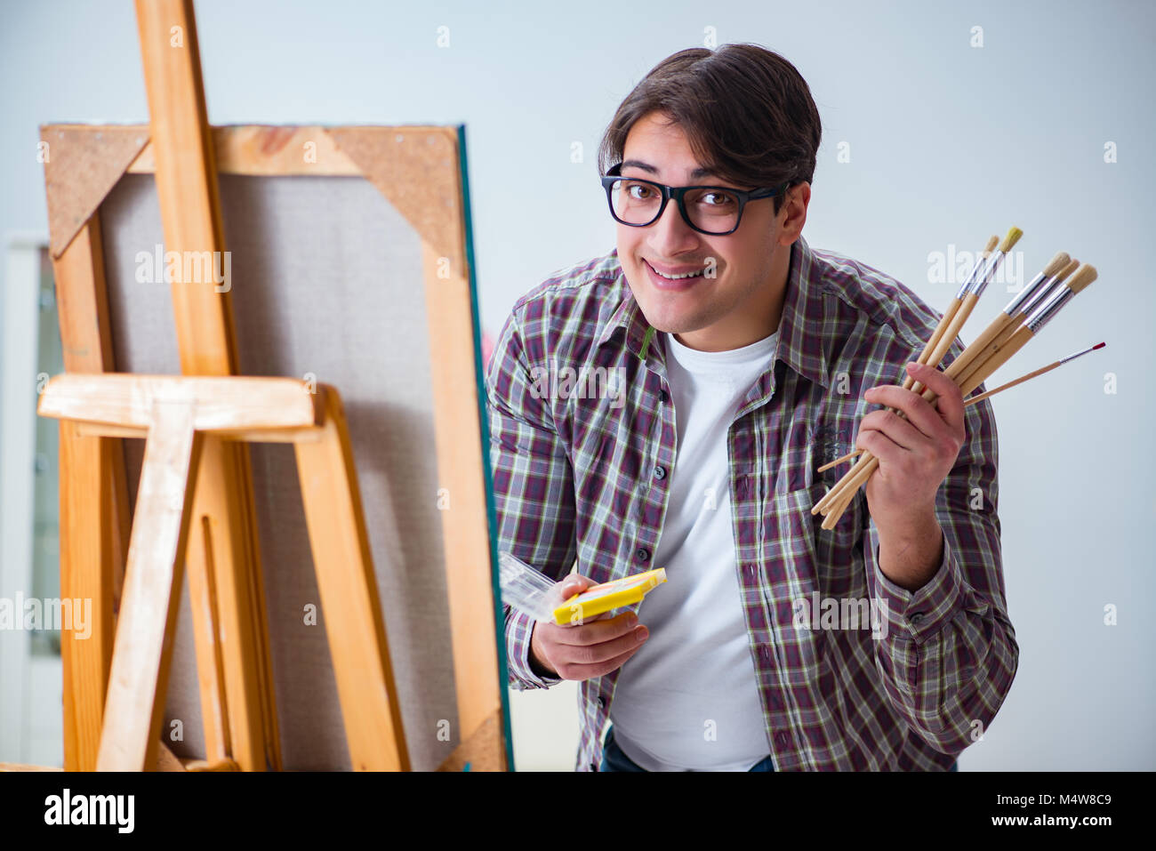 Young male artist drawing pictures in bright studio Stock Photo - Alamy