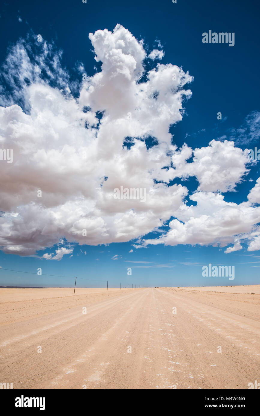 vibrant image of desert road and blue cloudy sky Stock Photo - Alamy