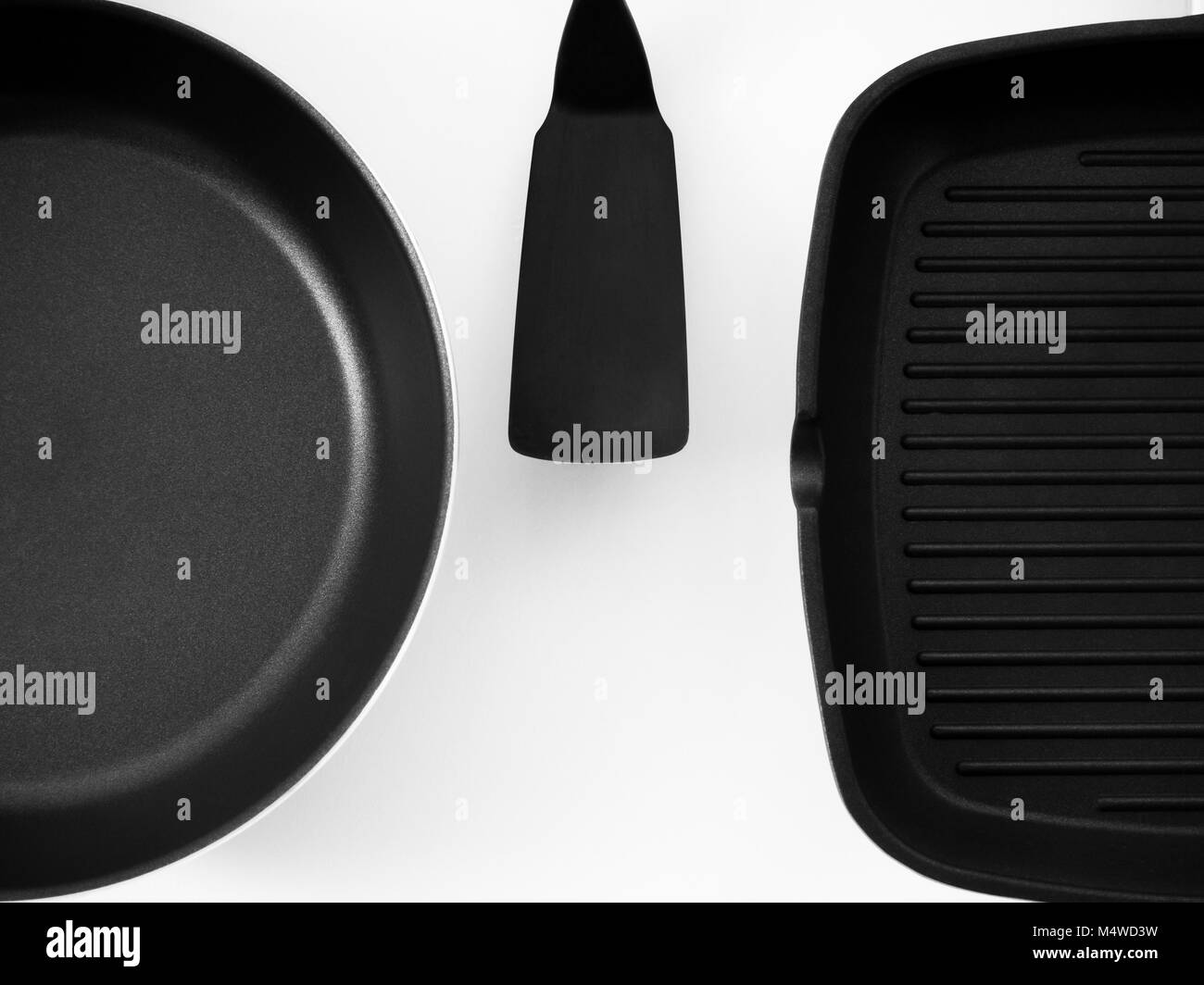 frying pans hanging on a white wall Stock Photo Alamy
