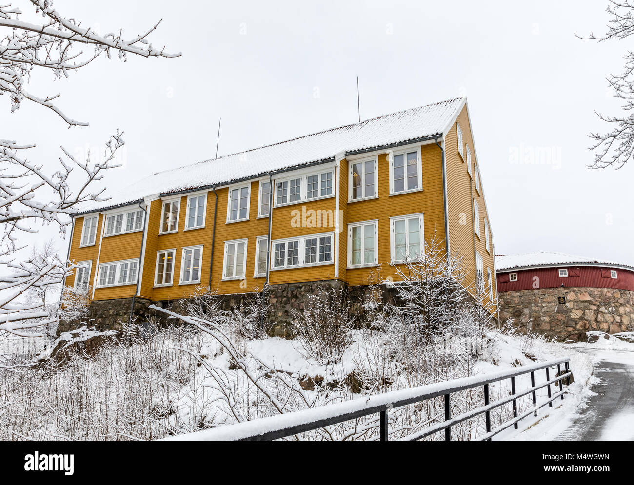 Odderoya in Kristiansand, Norway - January 17, 2018: Lasarettet, old yellow building from 1804, buildt as a quariantine to prevent spread cholera disease. Picture taken in winter, snow on the ground. Stock Photo