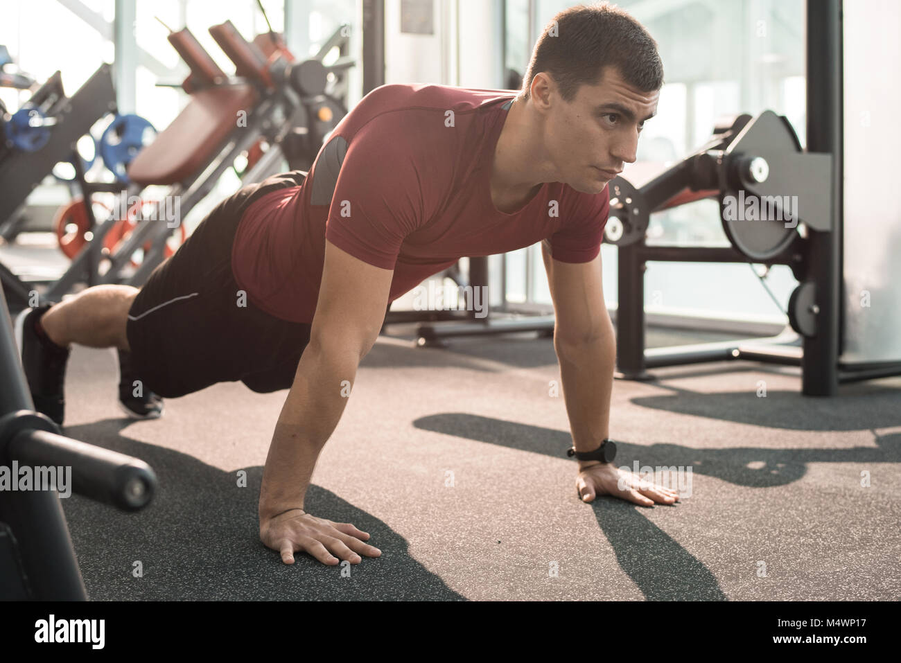 Full length portrait of handsome muscular man doing push ups training ...