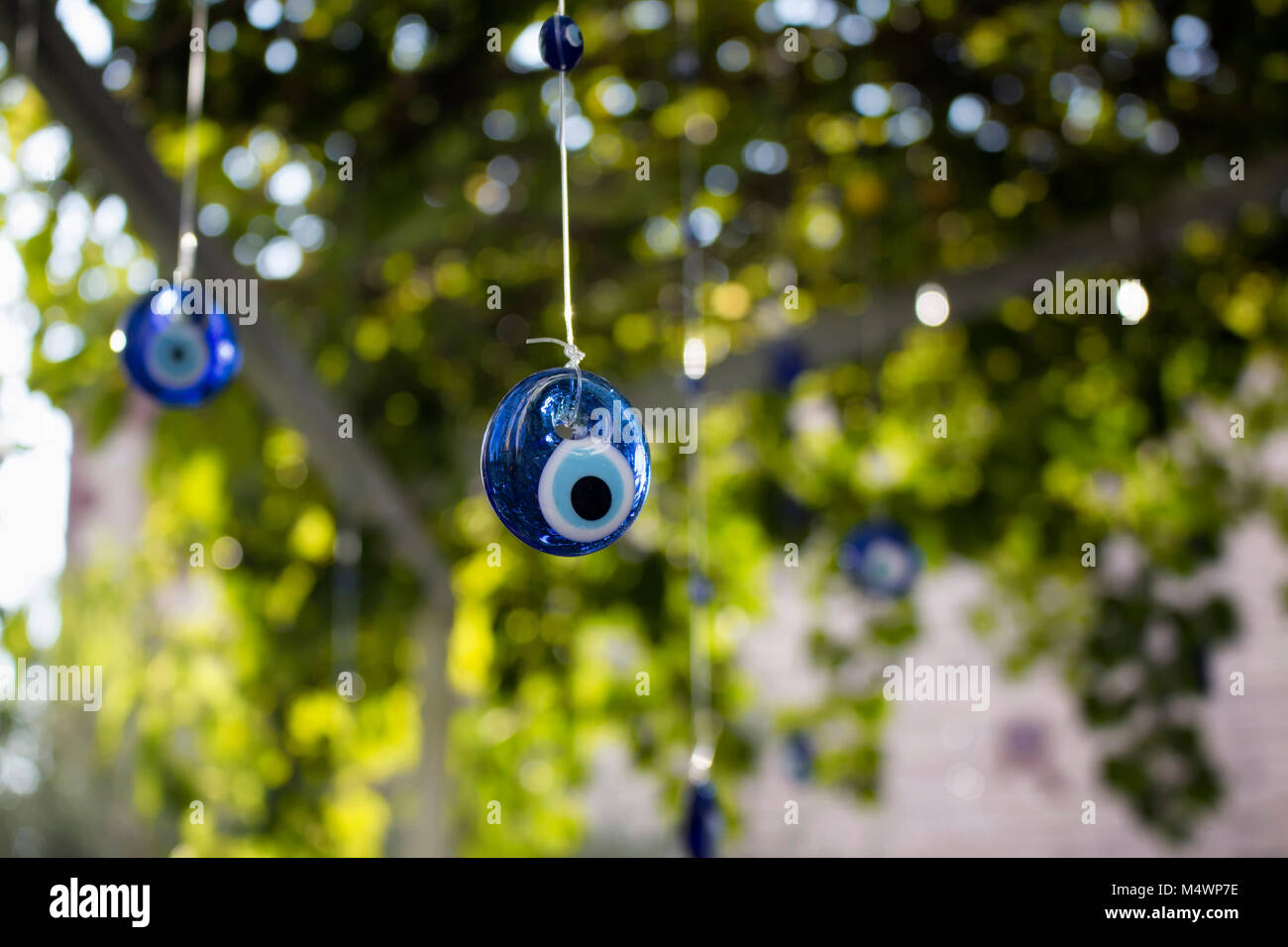Evil eyes are hung in decorative purpose with a tree in the background in Cunda (Alibey) island. Stock Photo