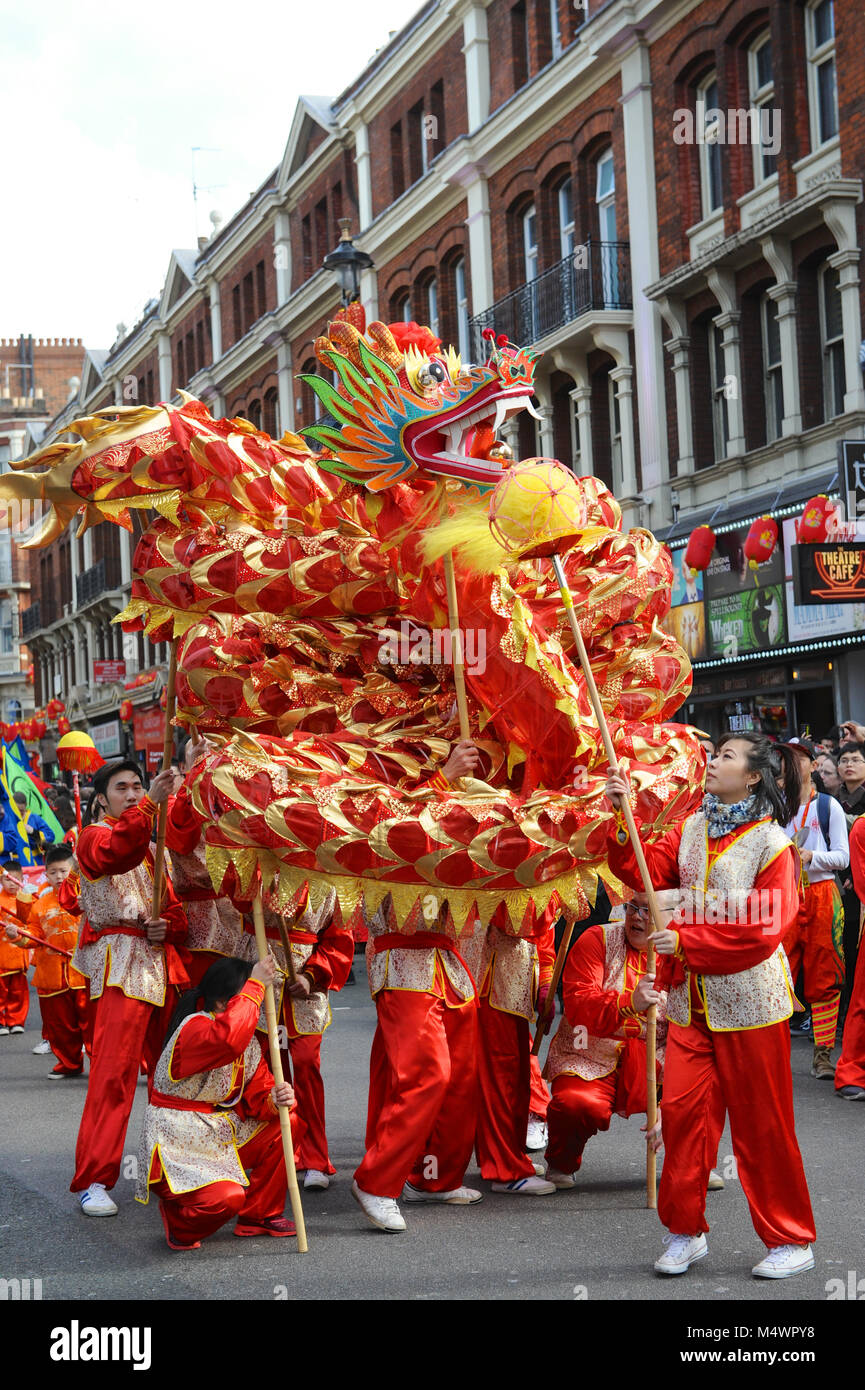 A ceremonial dragon is danced through the streets of Chinatown, London, England, United Kingdom as part of Chinese New Year celebrations.  Crowds lined the streets to watch the celebrations and festivities which are the largest outside Asia and featured the largest gathering of Chinese Dragon and Lion teams, 50 in total, performing the biggest festival dance in a public parade in Europe.  This year marks the arrival of the Year of the Dog, the eleventh animal in the Chinese zodiac. Dogs are especially auspicious as they symbolise the coming of fortune, and those born in the year of the dog are Stock Photo