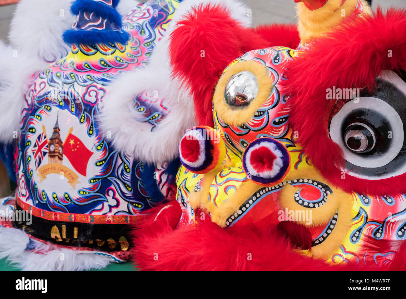 The heads of the flying lions wait in front of the stage with the motto, China UK Gold Era - Chinese New Year Celebrations in London 2018 marking the arrival of the Year of the Dog. The Event started with a Grand Parade from the North East side of the Trafalgar Square and finishing in Chinatown at Shaftesbury Avenue. It was organised by London Chinatown Chinese Association and is supported by The Mayor of London and Westminster City Council. Credit: Guy Bell/Alamy Live News Stock Photo