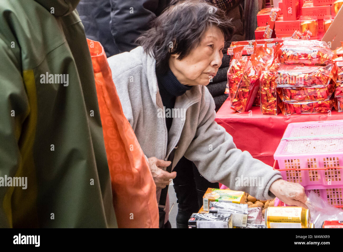 . Chinese New Year celebration in Chinatown, London,  Large crowds flock to Chinatown for the celebration, said to be the  largest outside China, A stall holder sells lucky charms for New Year Credit: Ian Davidson/Alamy Live News Stock Photo