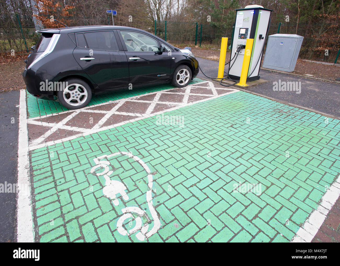 A Nissan Leaf electric car using a tri-rapid charger at a electric vehicle charging station, Riccarton, Edinburgh. Stock Photo