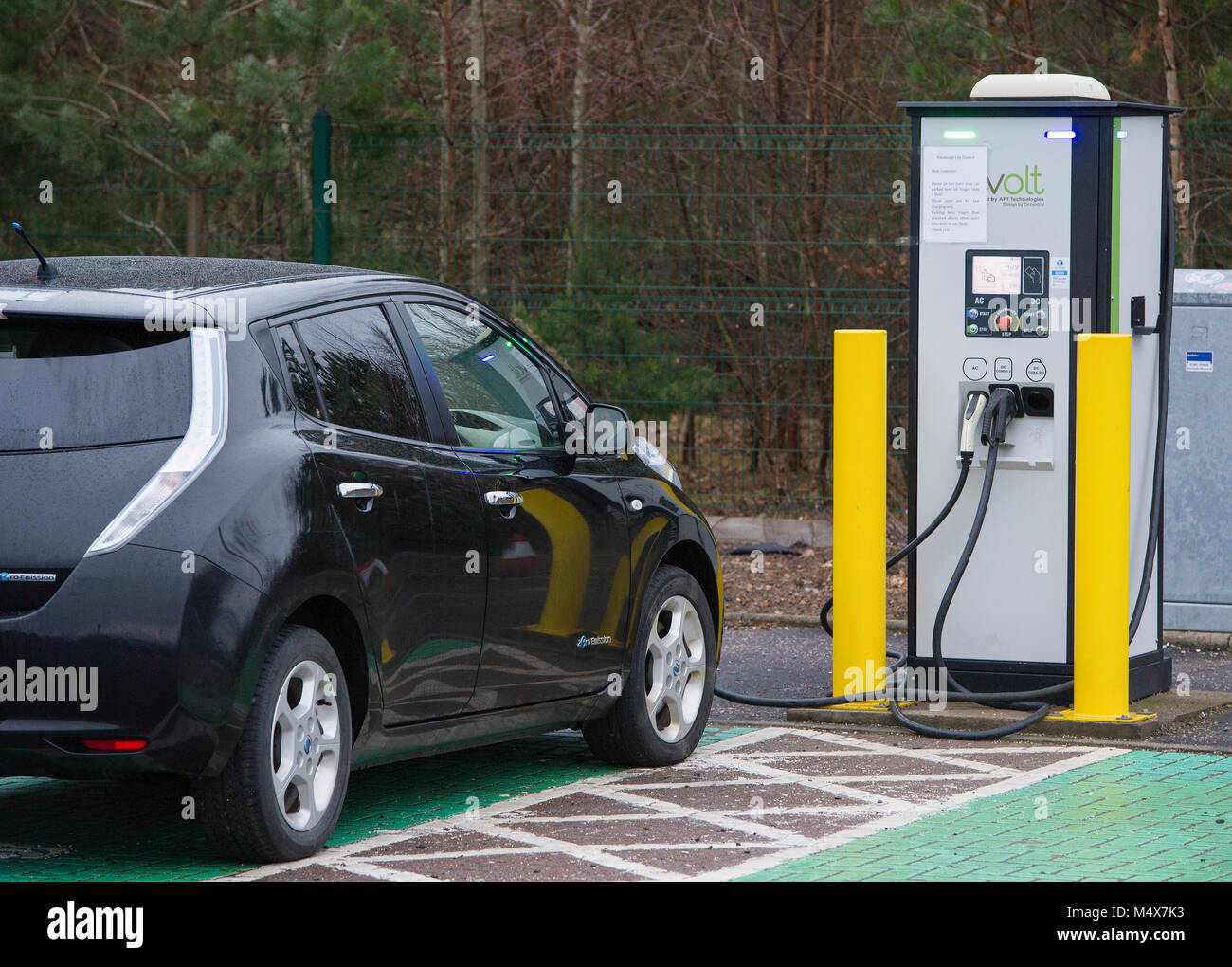 A Nissan Leaf electric car using a tri-rapid charger at a electric vehicle charging station, Riccarton, Edinburgh. Stock Photo