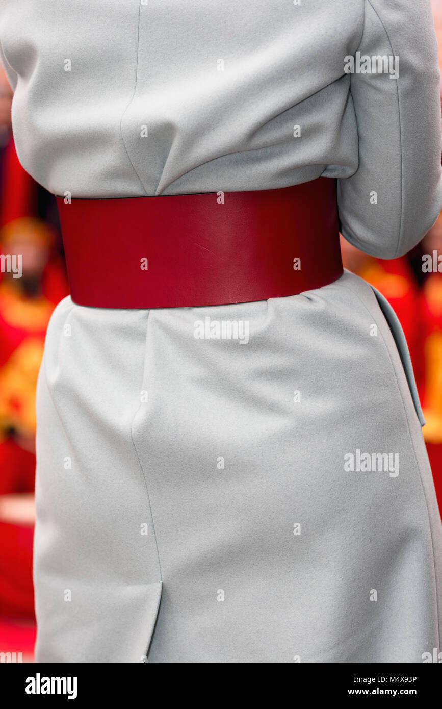 Wide red belt on white female dress Stock Photo