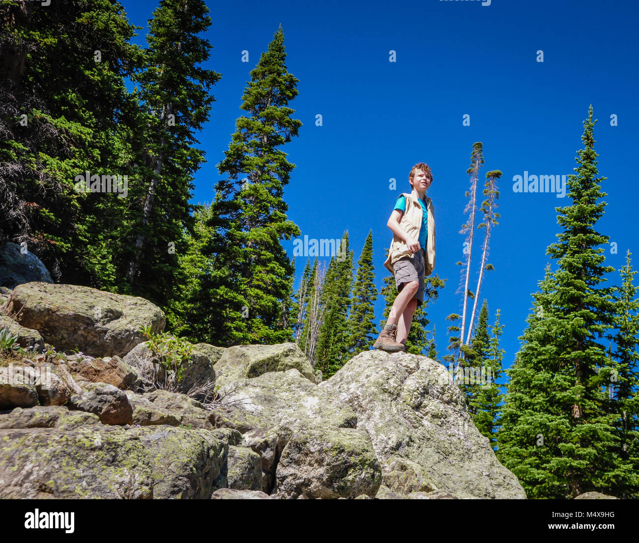 Young boy summits Rocky Mountain peak. Stock Photo