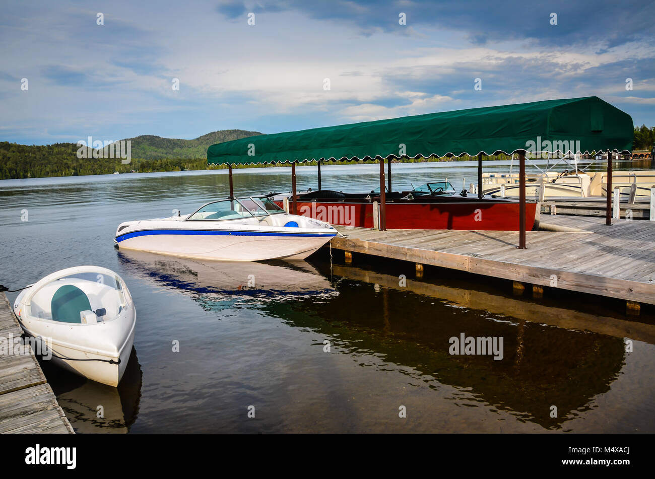 Classic boats moored at a dock on Lake Placid in the Adirondack Mountains of Upstate New York. Stock Photo