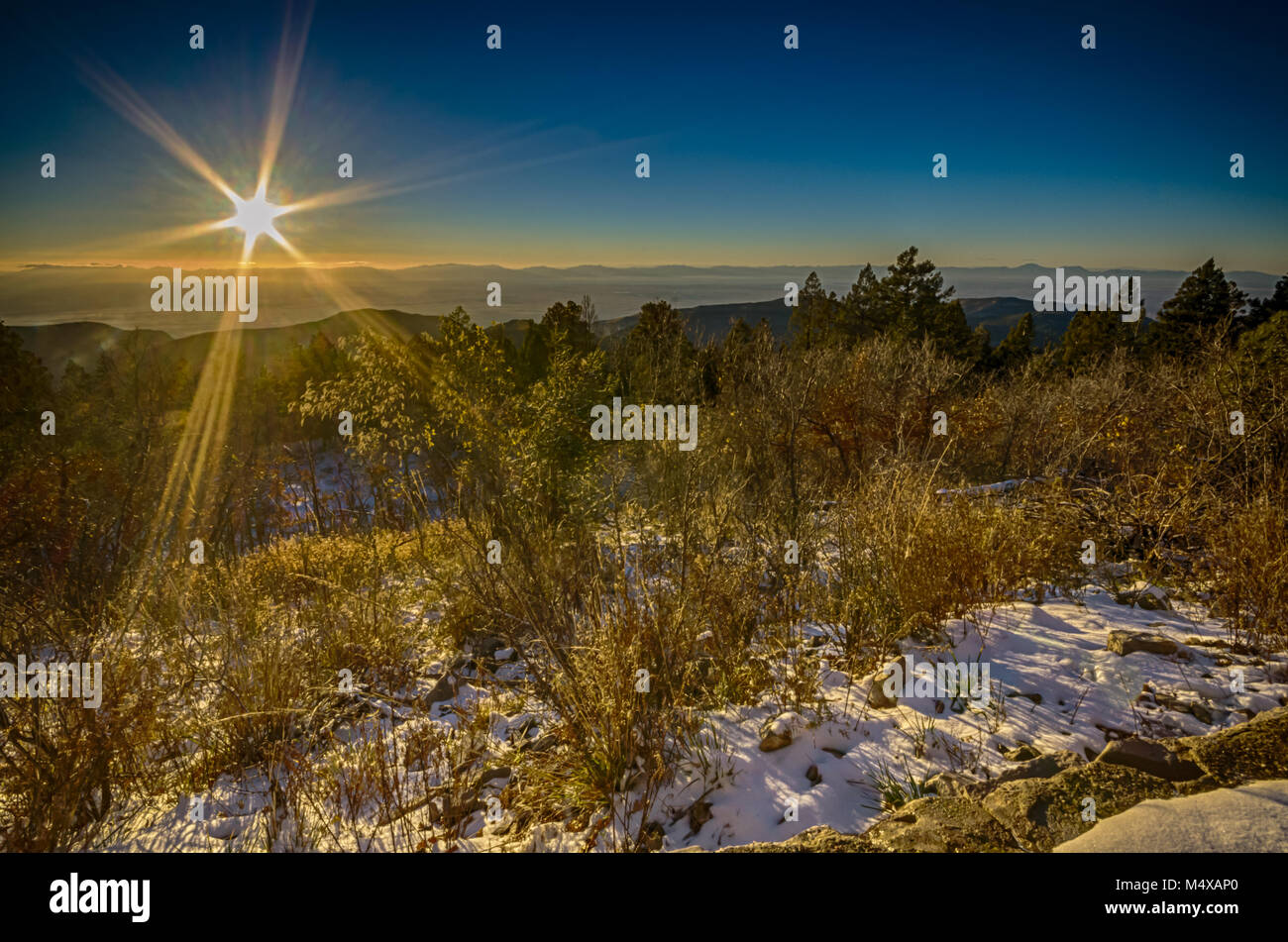 A solar starburst over a mountain snow landscape at Sunspot Astronomy Visitor Center near Cloudcroft, NM. Stock Photo