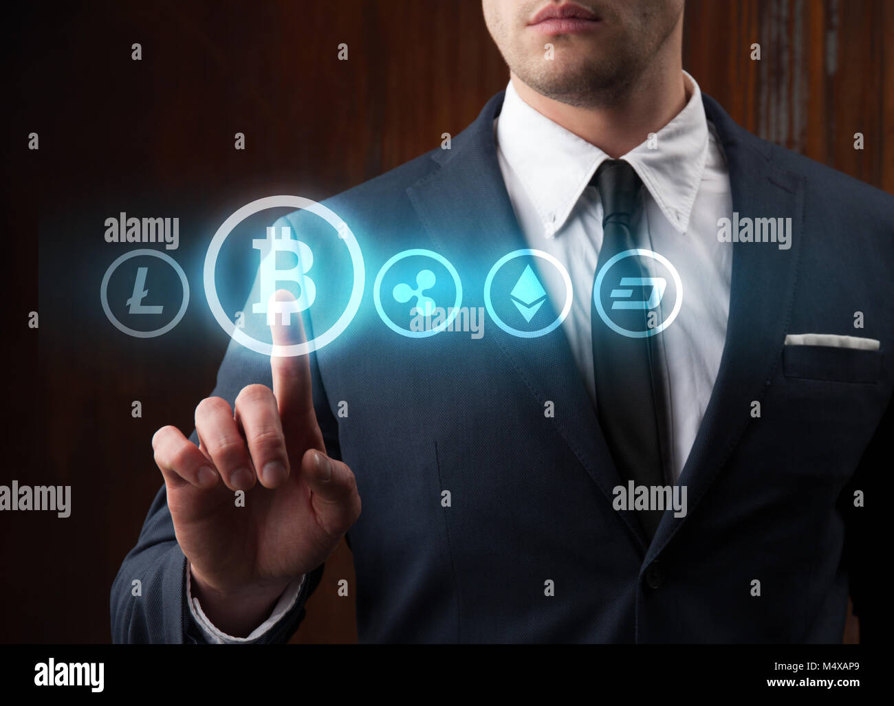 Businessman pressing bitcoin icon choosing from other cryptocurrency. Bitcoin, ripple, litecoin, dash, ethereum Stock Photo