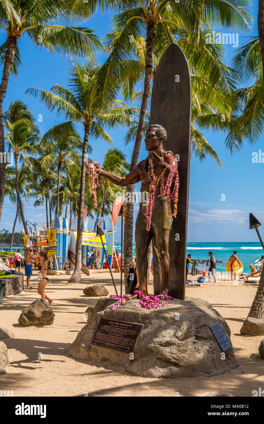 Duke Kahanamoku statue, famous Hawaiian surfer and Olympian on Waikiki Beach with sunbathers, surfers, tourists in Honolulu, Oahu,  Hawaii, USA. Stock Photo