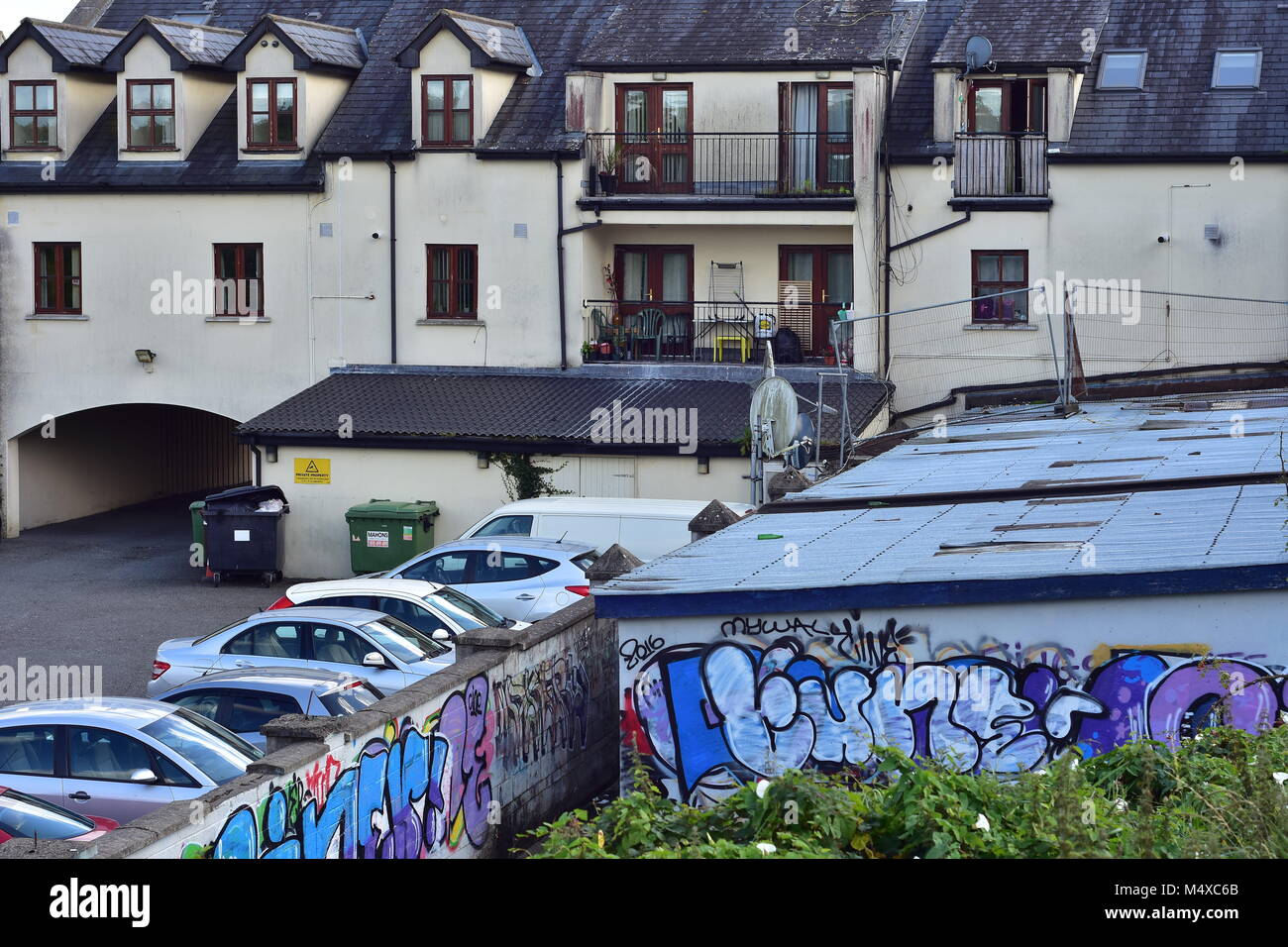 Apartments backyard with parking lots and rubbish bins in small town of
