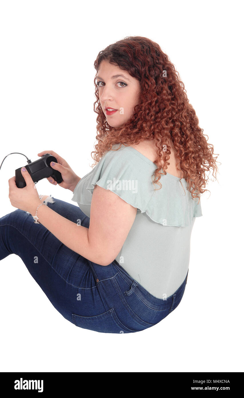Woman sitting on floor playing her video game Stock Photo