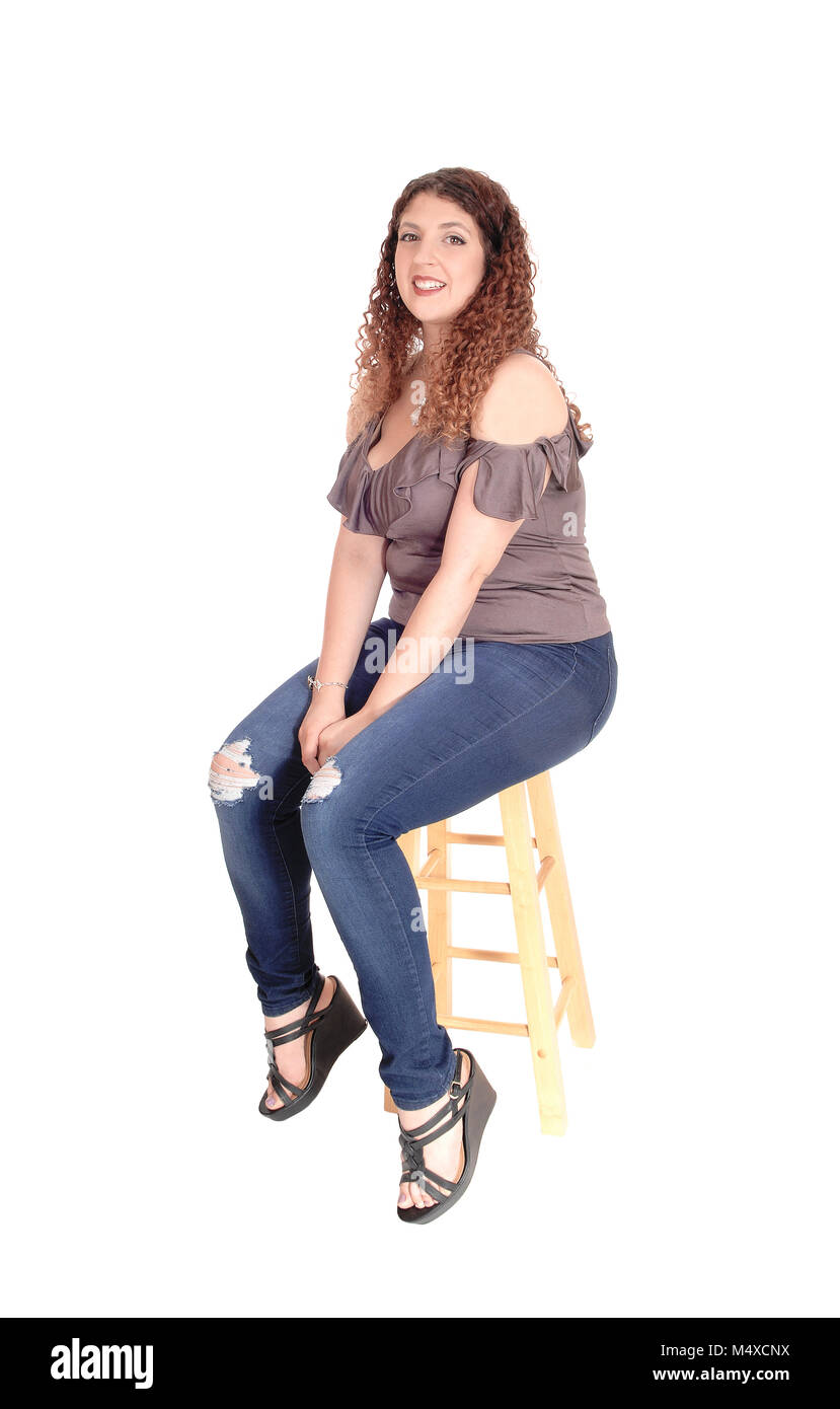 Young woman sitting on a bar chair, smiling Stock Photo