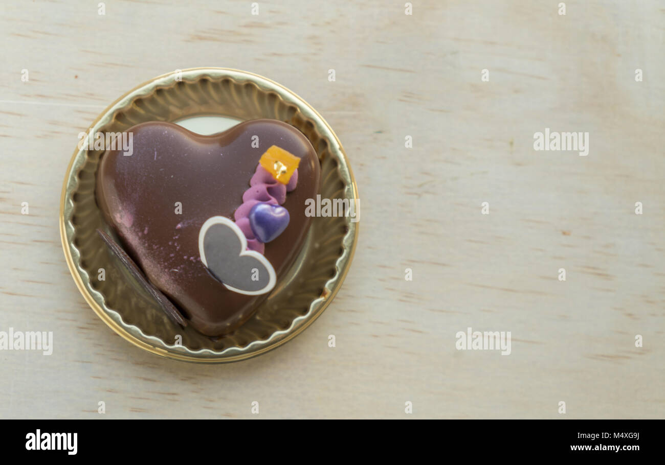 Fancy Heart shaped chocolate cake on a wooden table Stock Photo